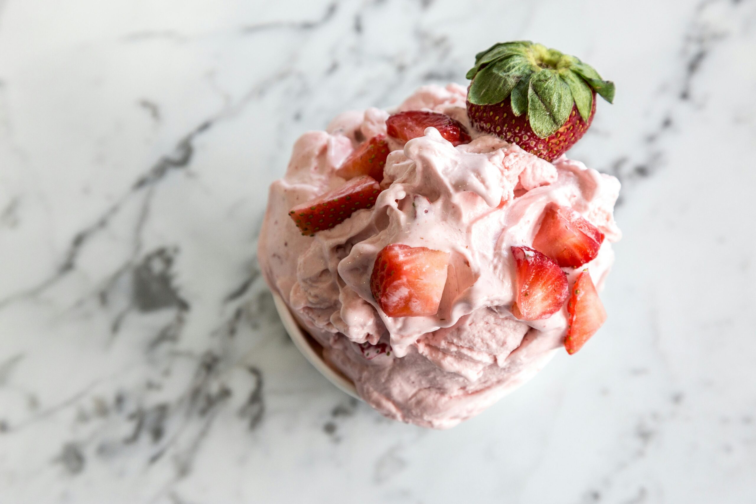 ¡El verano está aquí y con él llegan las ganas de algo refrescante y delicioso! ¿Y qué mejor que un buen helado? Pero, ojo, porque muchas opciones comerciales están cargadas de azúcares, grasas poco saludables y un sinfín de ingredientes artificiales. No te preocupes, en FitnessLife te traemos la solución perfecta: helados fit caseros, llenos de sabor, nutrientes y sin remordimientos.

Lo mejor de todo es que no necesitas ser un chef experto ni tener equipamiento especial. Con unos pocos ingredientes y un poco de paciencia, podrás disfrutar de estas recetas fáciles, deliciosas y totalmente saludables. ¡Vamos a ello!

### 1. Helado Fit de Chocolate Negro y Plátano
Si eres fan del chocolate, esta versión saludable te va a encantar.

#### Ingredientes:
- 500g de tofu sedoso
- 4 plátanos maduros medianos
- 6 cucharadas de cacao puro en polvo
- 2 cucharadas de sirope de ágave
- 7 gotas de extracto de vainilla

#### Preparación:
1. Pela los plátanos y colócalos en el vaso de la batidora junto con el tofu, el cacao, el sirope de ágave y el extracto de vainilla.
2. Tritura bien hasta obtener una mezcla homogénea y cremosa.
3. Vierte la mezcla en un recipiente y guárdalo en el congelador. Remueve cada 30 minutos para evitar que se formen cristales de hielo.
4. En aproximadamente una hora, tu helado estará listo para disfrutar.

#### Tip extra:
¡Dale un toque gourmet! Agrega una pizca de jengibre, anís estrellado o nuez moscada antes de batir.

### 2. Helado Proteico de Tarta de Queso y Frutas del Bosque
Este helado es perfecto para quienes buscan un extra de proteína y frescura en cada cucharada.

#### Ingredientes:
- 500g de queso fresco batido descremado (0% grasas)
- 100g de arándanos congelados
- 6 dátiles deshuesados
- 100g de frambuesas congeladas
- Ralladura de 1 limón
- 100g de moras congeladas
- 7 gotas de extracto de almendras

#### Preparación:
1. En el vaso de la batidora, coloca las bayas congeladas, los dátiles, la ralladura de limón, el queso fresco y el extracto de almendras.
2. Tritura hasta obtener una textura cremosa.
3. Vierte la mezcla en un recipiente con tapa y guárdalo en el congelador.
4. Si utilizaste ingredientes bien fríos, con 30 minutos en el congelador tendrá la textura perfecta.

#### Tip extra:
¡Dale más proteína! Agrega 4 cucharadas de proteína en polvo sabor fresa para potenciar su valor nutricional.

### 3. Helado Fit de Melocotón, Vainilla, Canela y Chocolate
Una combinación irresistible de sabores para refrescarte sin culpa.

#### Ingredientes:
- 3 melocotones grandes maduros
- 1/2 litro de leche evaporada
- 2 y 1/2 cucharadas de sirope de ágave
- 2 cucharadas de cacao puro en polvo
- 1/4 cucharadita de canela en polvo
- 7 gotas de extracto de vainilla

#### Preparación:
1. Pela y trocea los melocotones. Congélalos previamente en una bandeja con papel de horno.
2. Mezcla la leche evaporada con 2 cucharadas de sirope de ágave, la vainilla y la canela. Congélala en un recipiente con tapa durante 40 minutos.
3. Prepara un sirope de chocolate mezclando el cacao en polvo con el sirope de ágave restante y un poco de agua.
4. Bate los melocotones congelados con la leche evaporada y sirve con el sirope de chocolate por encima.

#### Tip extra:
Puedes sustituir el melocotón por albaricoques o nísperos para variar los sabores.

---

## ¡Este verano, los helados fit son la mejor opción!
Ya no hay excusas para evitar los helados. Con estas recetas, puedes disfrutar de un postre delicioso, saludable y acorde a tu estilo de vida fitness. Anímate a experimentar con diferentes frutas y especias para personalizar tu helado ideal. ¡En FitnessLife sabemos que cuidarse no significa renunciar al placer!

